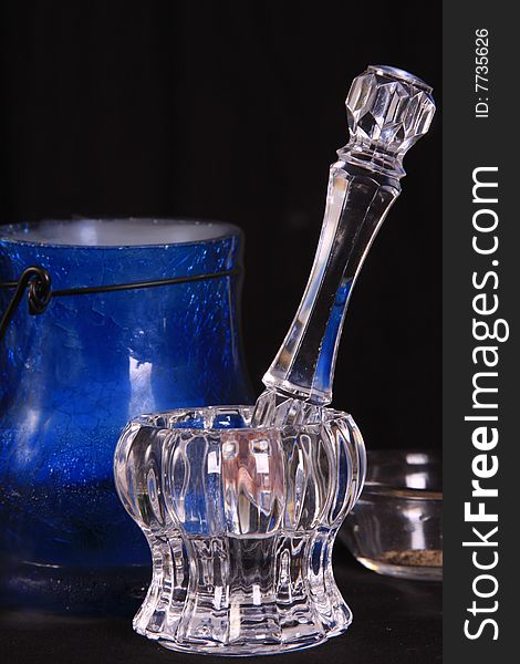 Blue cauldron with smoke coming out of it in the background of a crystal mortar and pestle