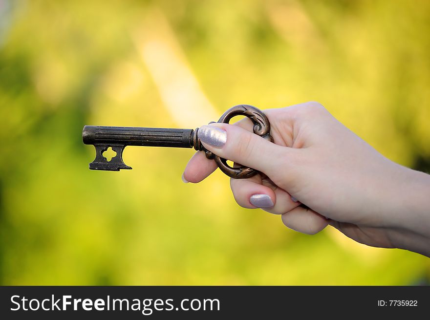 Key in a hand on bright background. Key in a hand on bright background