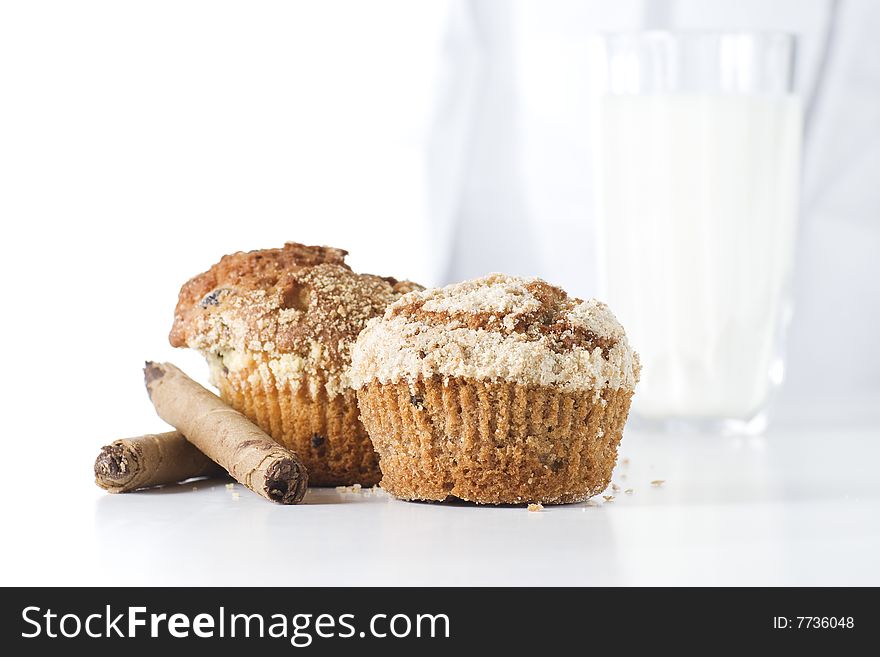 Two muffins on white background with glass of milk