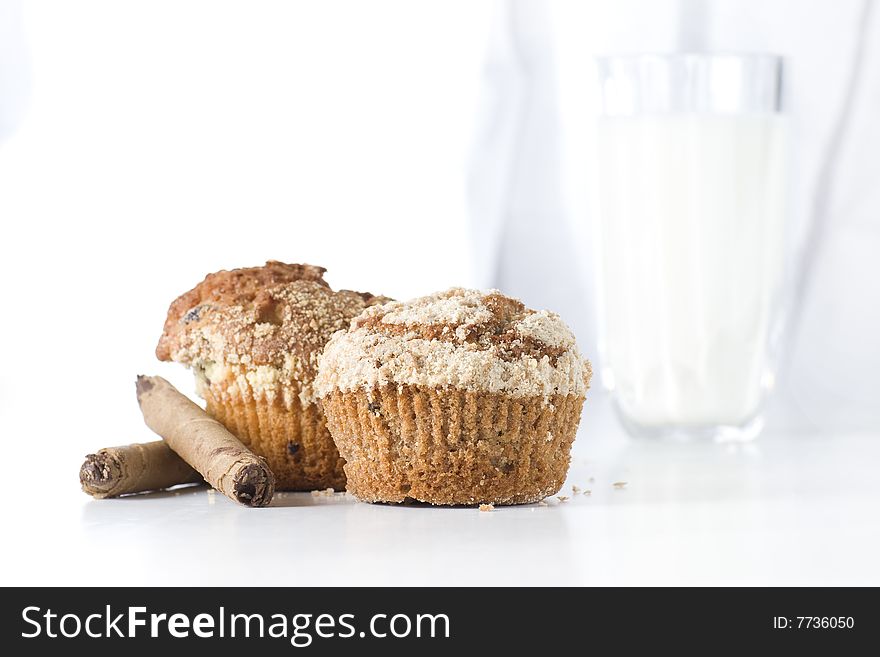 Two muffins on white background with glass of milk