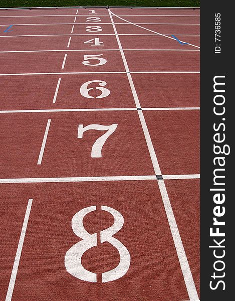 Numbered starting lanes on running track.