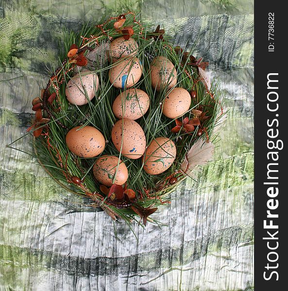 Decorated eggs in a wreath on a green background. Decorated eggs in a wreath on a green background