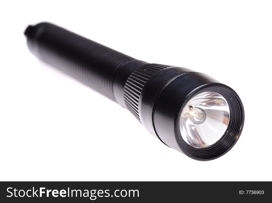 Small black flashlight isolated on the white background. Narrow depth of field. Small black flashlight isolated on the white background. Narrow depth of field.