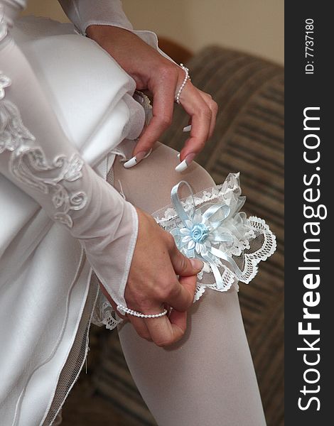 A bride putting on her wedding garter. A bride putting on her wedding garter