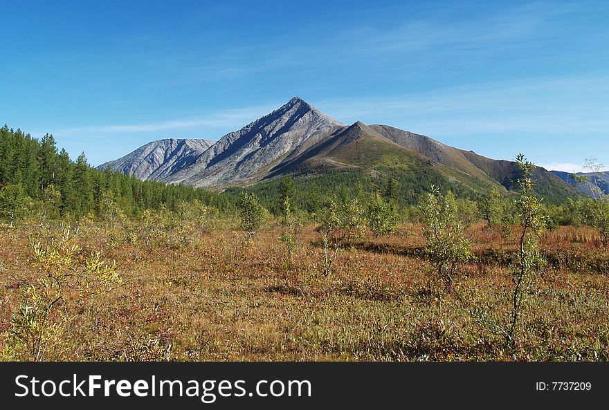 Photo. Mountain and hills against a backdrop of blue sky. Forest. Photo. Mountain and hills against a backdrop of blue sky. Forest.