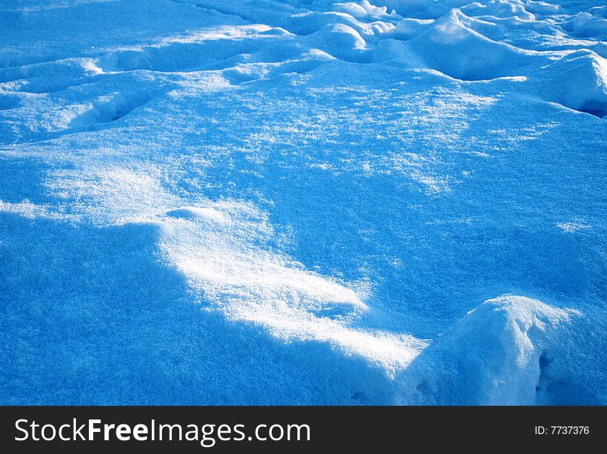 Tracks sprinkled snow. It is taken picture in a sun day - pls are deep dark blue, snow sparkles.