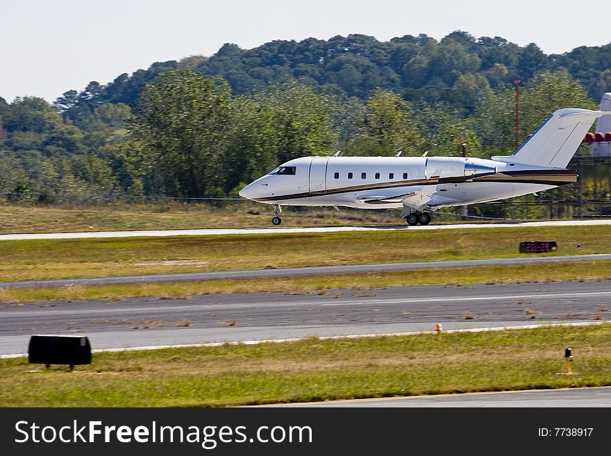 A private jet taking off with front wheel just off the ground. A private jet taking off with front wheel just off the ground