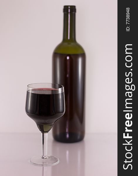 Glass and bottle with red wine. Small depth.