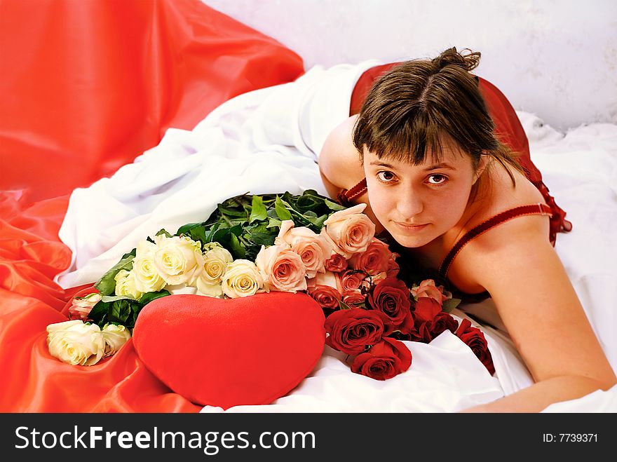 Girl, lying on beds, heart and roses with it alongside. Girl, lying on beds, heart and roses with it alongside.