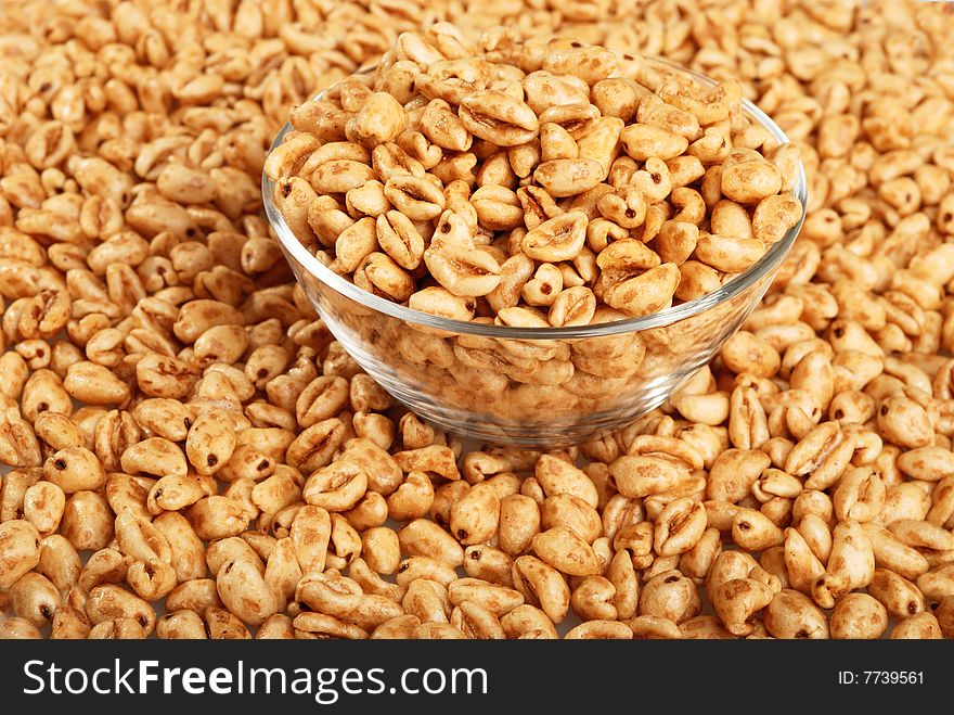 Background with popped wheat grains in cup