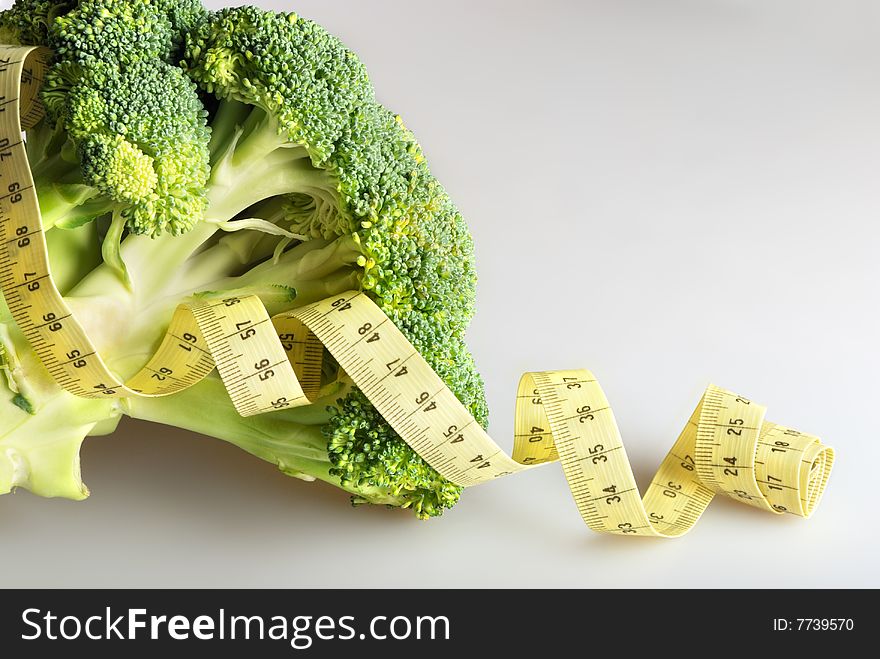 Green broccoli (part of inflorescence) with tape measure. Green broccoli (part of inflorescence) with tape measure