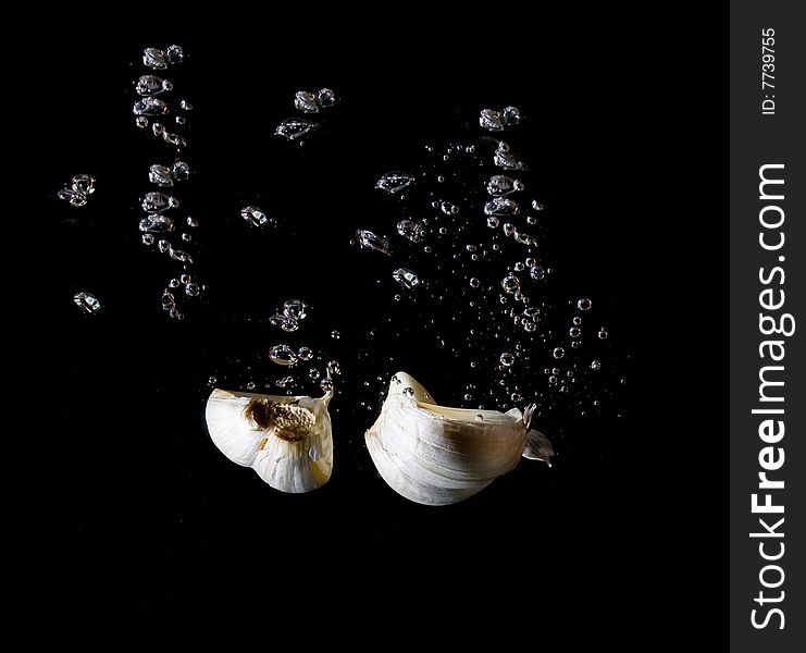 Garlic in wateron black background