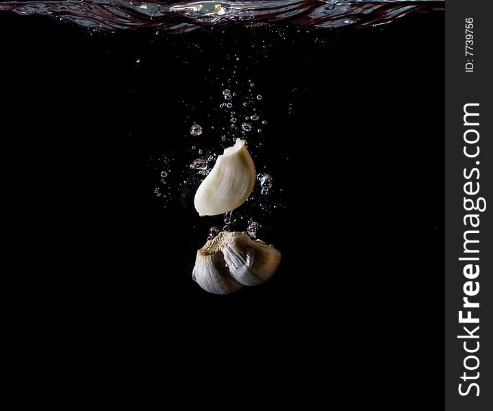 Garlic in wateron black background