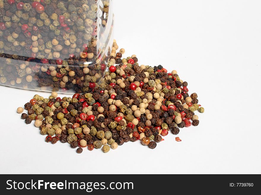 Heap of four kind of pepper over white table