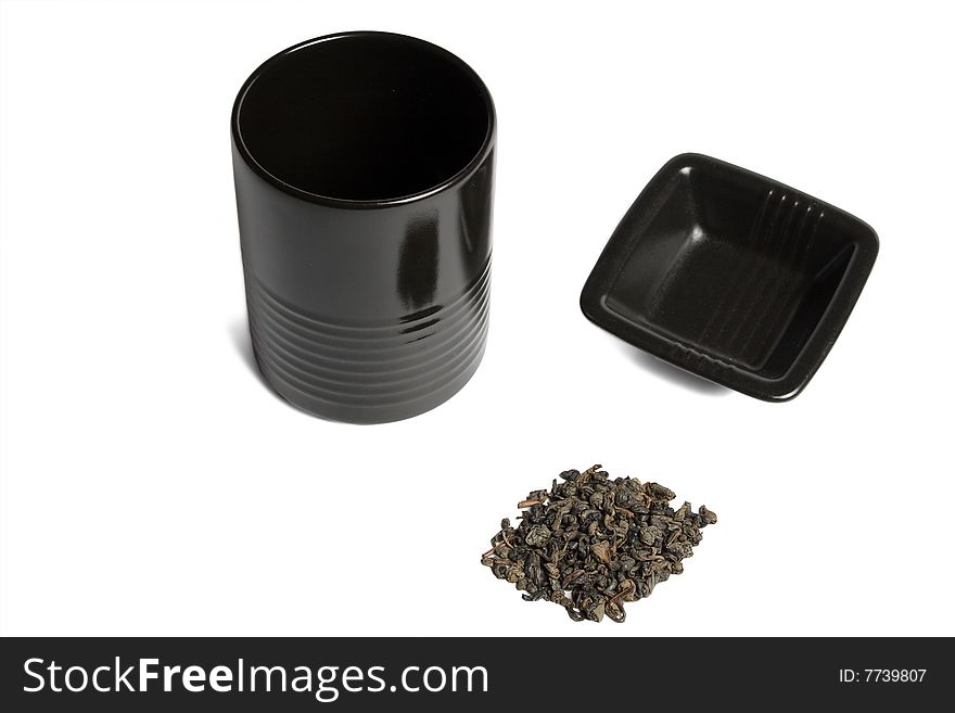 Black cup and green tea leaves isolated over white