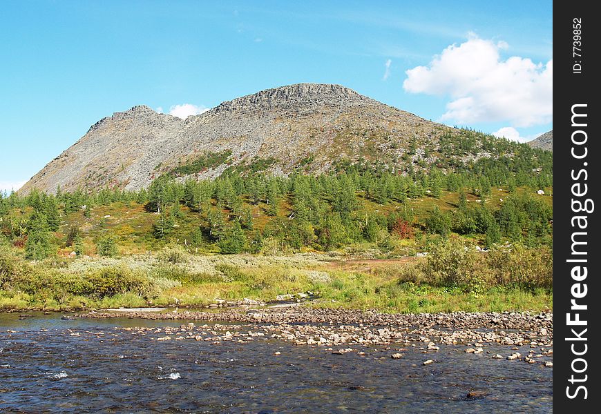 Mountain, forest and river against a backdrop of blue sky. Mountain, forest and river against a backdrop of blue sky.