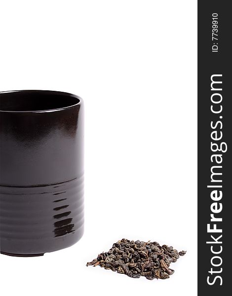 Black cup heap of green tea leaves isolated over white