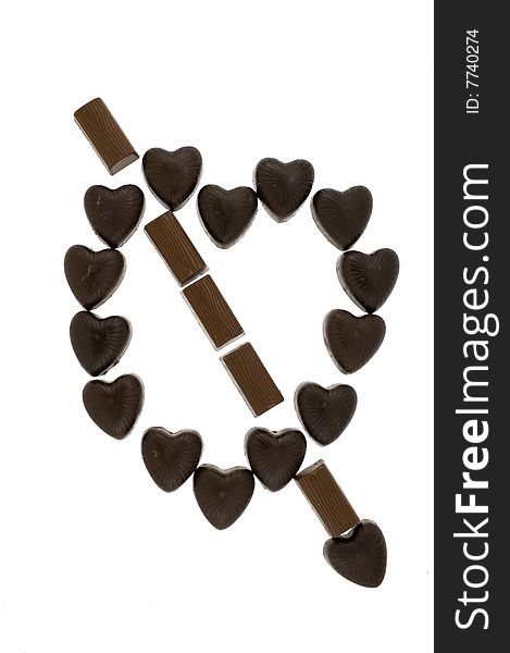 Chocolate sweets in the form of heart and arrow, on white