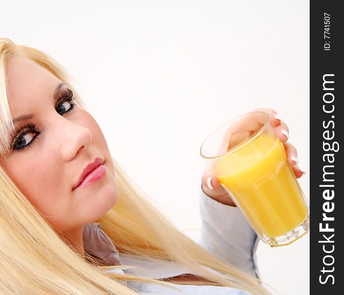 A young blond woman with a glass of orange juice. A young blond woman with a glass of orange juice
