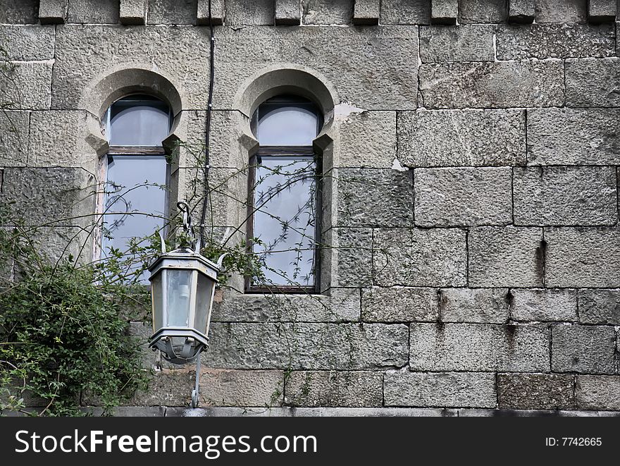 Fragment of old castle wall with windows and lantern