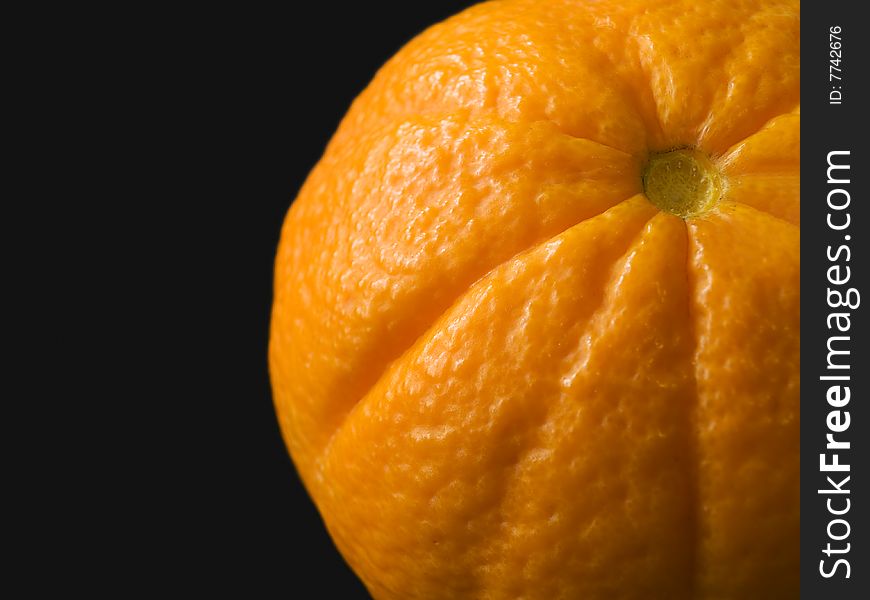 Close up of an orange peel on a black background.