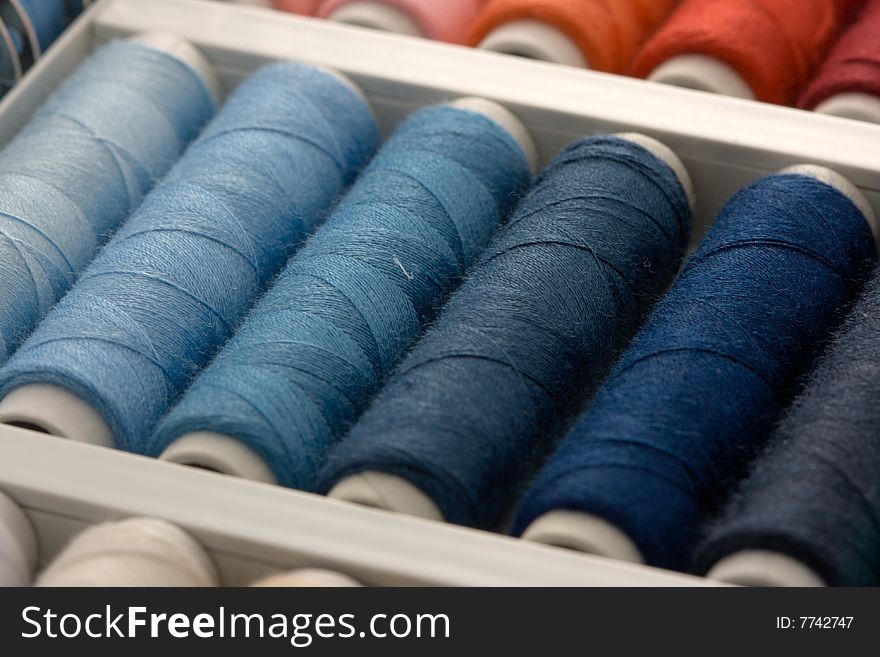 Colorful spools of thread in a box