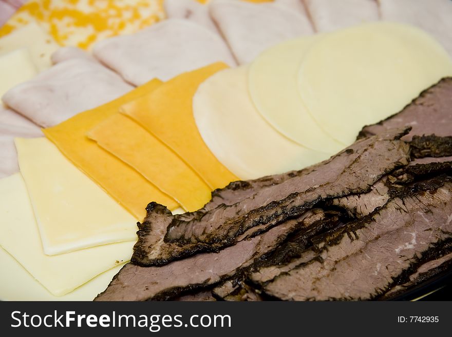 Sliced meats and cheeses on a deli platter. Sliced meats and cheeses on a deli platter