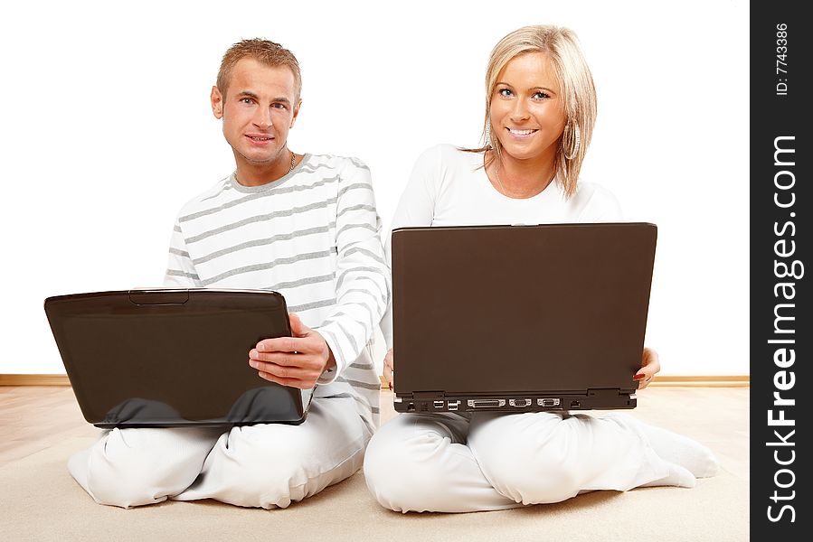 Portrait of a happy couple sitting on the floor with laptop. Portrait of a happy couple sitting on the floor with laptop