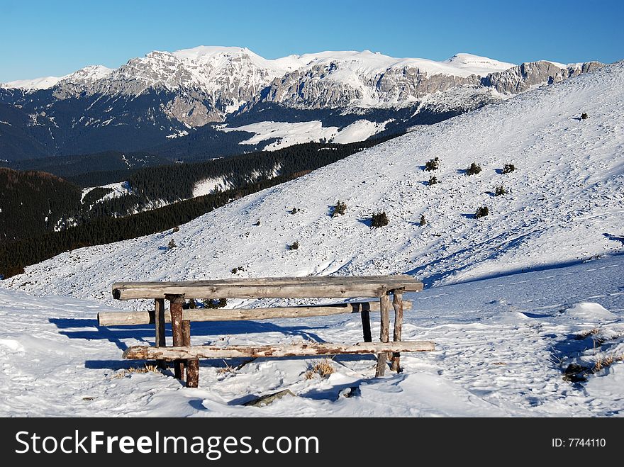 Resting place in Leaota Mountains (Carpathian ridge). This seat is located at 1700 m altitude, on the foot of Santilia Peak (1887 m). In the background you can see Bucegi Mountains (2507 m altitude). Resting place in Leaota Mountains (Carpathian ridge). This seat is located at 1700 m altitude, on the foot of Santilia Peak (1887 m). In the background you can see Bucegi Mountains (2507 m altitude).