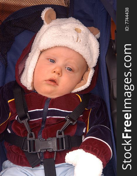 With a look of total boredom in his eyes, an infant boy sits in his stroller patiently waiting to get going. With a look of total boredom in his eyes, an infant boy sits in his stroller patiently waiting to get going.