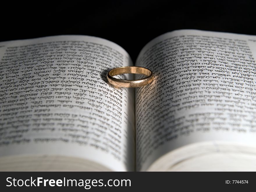 A males wedding ring on a bible. A males wedding ring on a bible