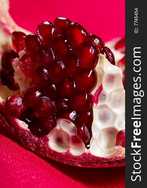 Fruit series: ripe pomegranate on the red background