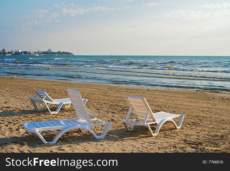 Three empty chaise-longue on the beach