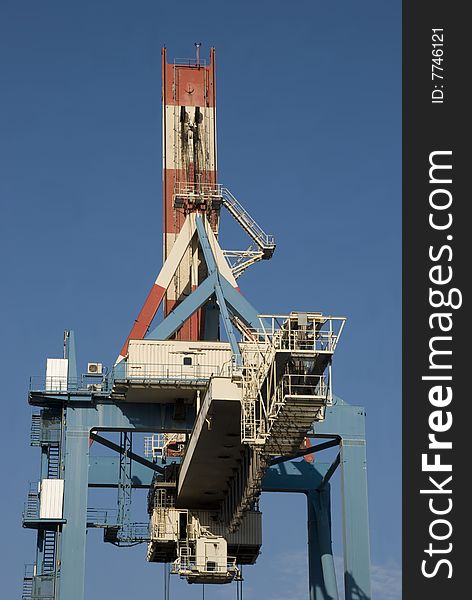 Heavy industrial crane used to load and unload large cargo ships at a port. Heavy industrial crane used to load and unload large cargo ships at a port