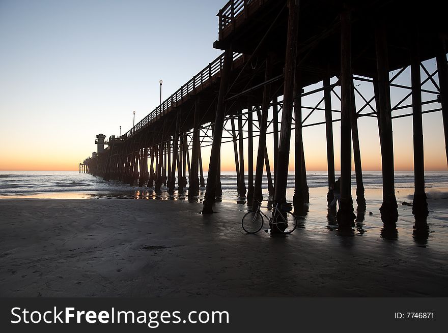 A pier on the coast of Southern California silhouetted against a sunset. A pier on the coast of Southern California silhouetted against a sunset.