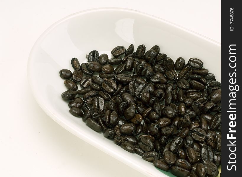 Fresh Arabica coffee beans in a white dish