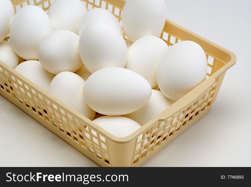 Fresh eggs in a basket on a white background