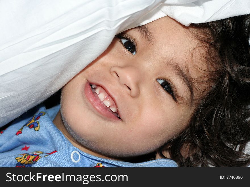 Little boy in hospital gown smiling under pillow. Little boy in hospital gown smiling under pillow