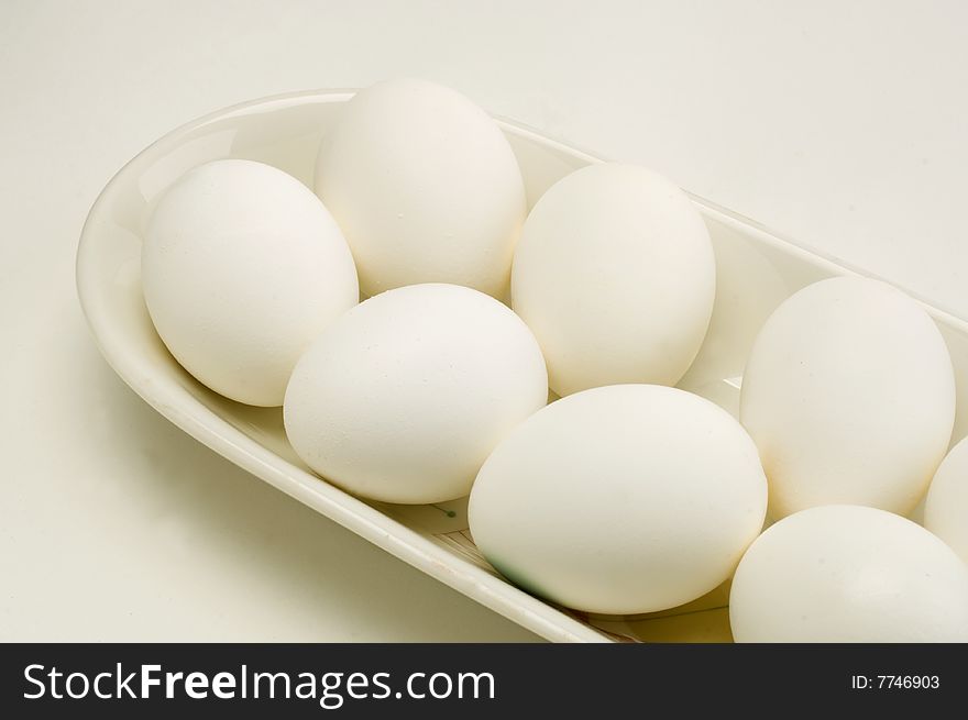 Fresh eggs in a white dish on a white background