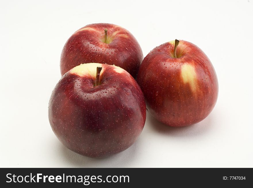 A group of three apples on a white background