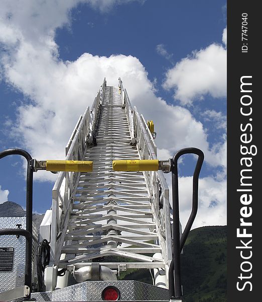 Extended fire truck ladder climbing towards a peaceful sky. Extended fire truck ladder climbing towards a peaceful sky