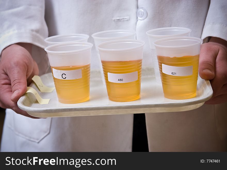 Amber liquid in plastic cups on plate
