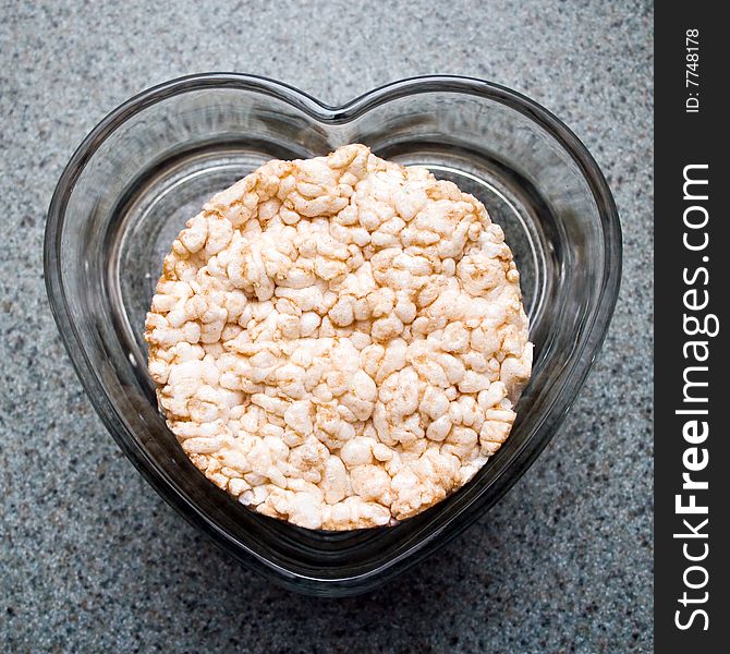 Rice cakes in a clear heart shaped dish on a kitchen counter. Rice cakes in a clear heart shaped dish on a kitchen counter.