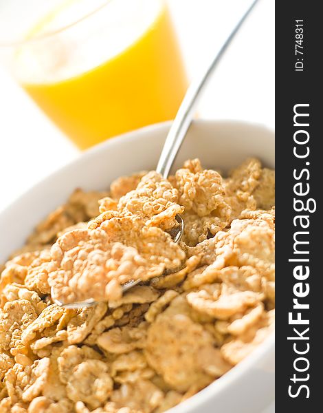 Bowl of cereal with raisins, milk and orange juice