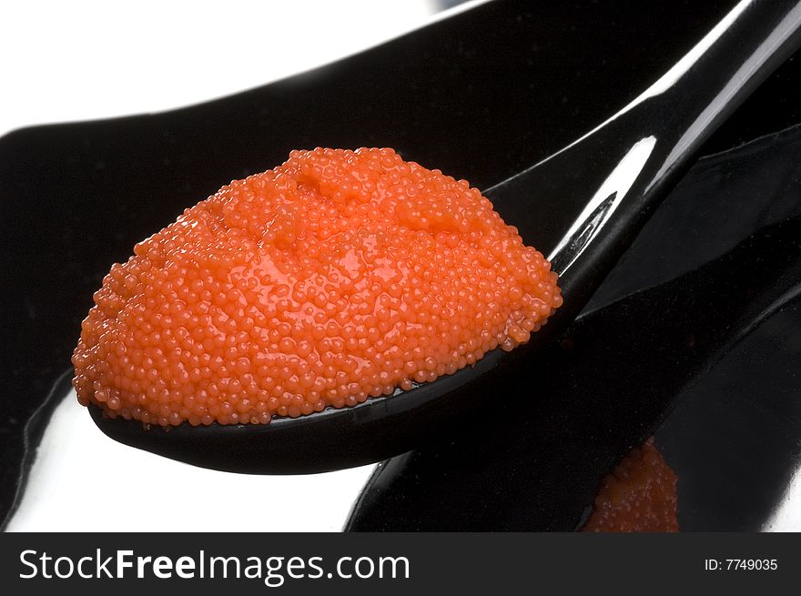 Red russian caviar in a black spoon