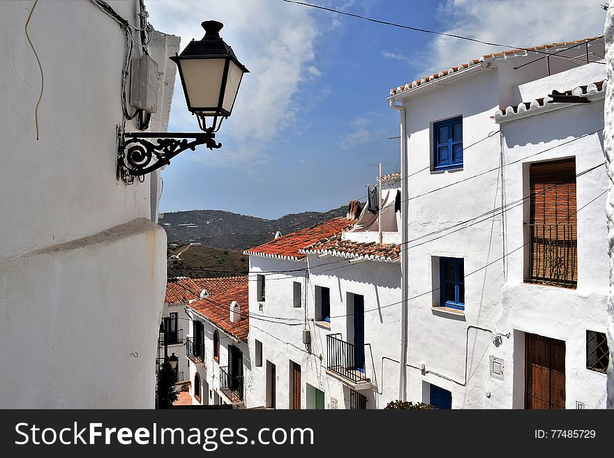 Beautiful and charming with its narrow streets and footpaths white village Frigiliana, close to Nerja - holiday destination of Costa del Sol, about 40 miles from Malaga. view from narrow street. Beautiful and charming with its narrow streets and footpaths white village Frigiliana, close to Nerja - holiday destination of Costa del Sol, about 40 miles from Malaga. view from narrow street.