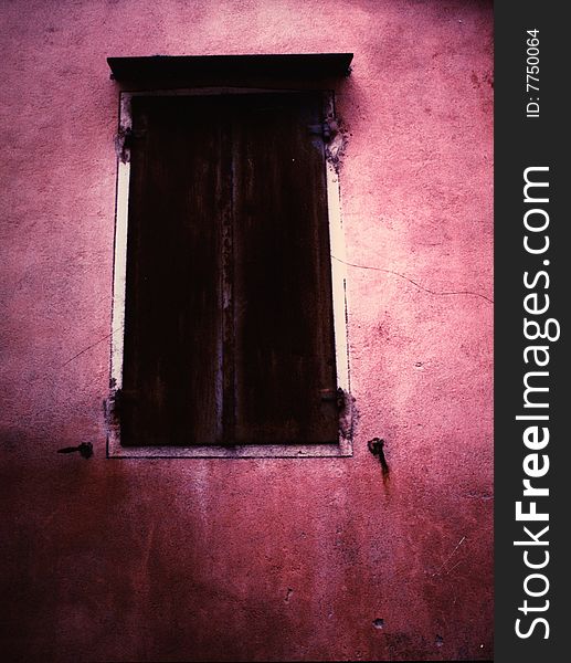 Old rusty window on a red wall