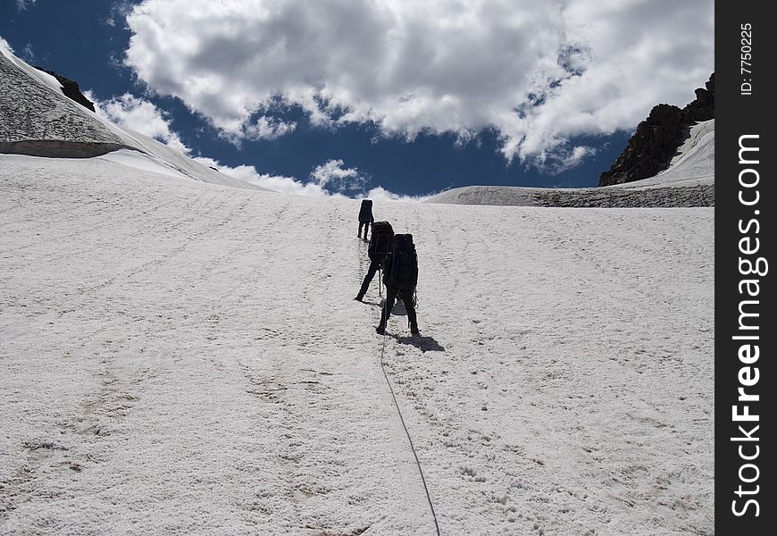 Climbers go on glacier. Ice