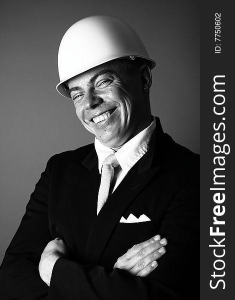 A black and white photograph of a happy man in workers helmet. A black and white photograph of a happy man in workers helmet
