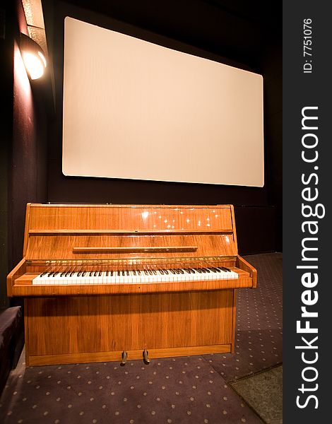 Empty cinema auditorium and a brown piano